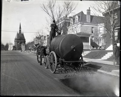 Camión de riego de calles trabajando en Washington Place cerca de la entrada desde Union Boulevard de Charles Clement Holt
